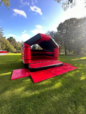 Adult Bouncy Castle Hire - Red and Black With Roof