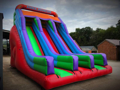 12ft Platform Twin Lane Rainbow Slide, a inflatable slide for hire from Animal Bouncers
