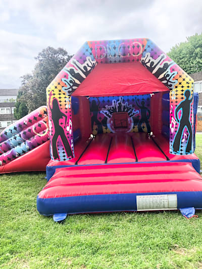 Party Disco Castle with Slide, a bounce and slide combo for hire from Happy Days Bouncy Castles