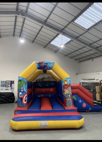 Superhero Bouncy Castle with Slide (17ft x 15ft), a bounce and slide combo for hire from The Bounce Generation