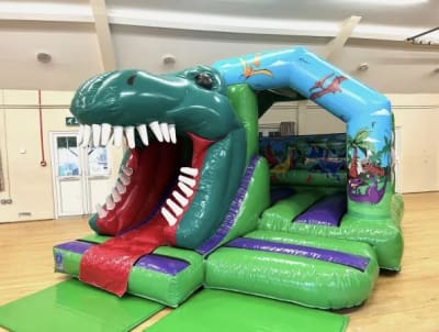 3D Dinosaur Castle with Slide, a bounce and slide combo for hire from Wazoggies Bounce House