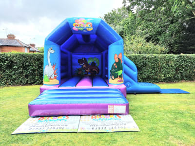 Dinosaur Castle/Slide Combo with roof, a bounce and slide combo for hire from Allsorts Inflatables