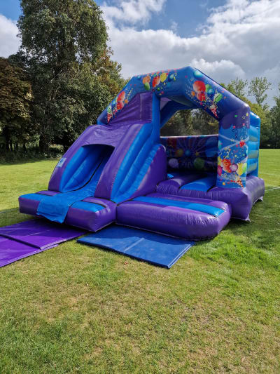 Party Themed Bouncy Castle & Slide (15x12ft), a bounce and slide combo for hire from Airscape Events