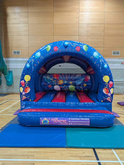 Blue/Red Party Time Curved Castle, a bouncy castle for hire from Every Bounce Counts