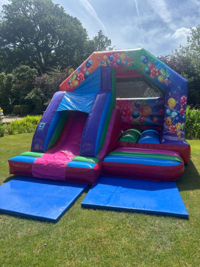 15x12ft Multicolored Party Front Slide Combi, a bounce and slide combo for hire from Bouncing Happy