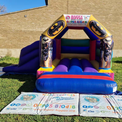Batman Slide 15ft x 18ft - Purple & Red, a inflatable slide for hire from Happy Hippos Bouncy Castles