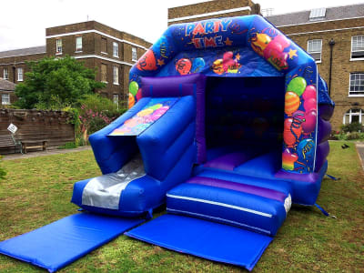 12 x 18 Party theme Combi slide bouncy castle, a bounce and slide combo for hire from TFG Bouncy Castles
