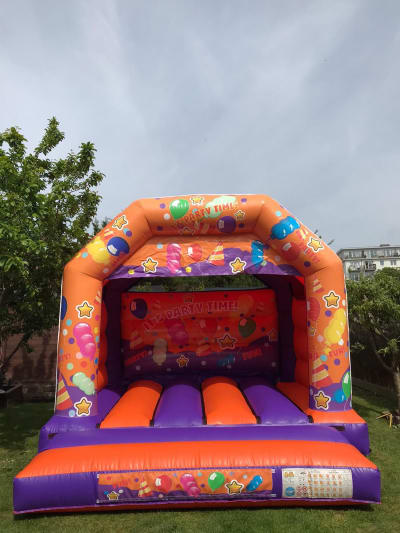 Orange and Purple Party Time Castle, a bouncy castle for hire from Chloe's Castles