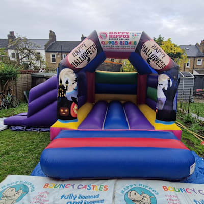Halloween Slide 15ft x 18ft - Purple & Red, a inflatable slide for hire from Happy Hippos Bouncy Castles