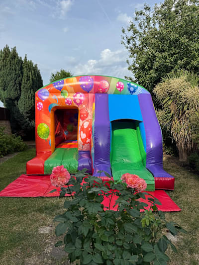 Rainbow Party Bounce n Slide, a bounce and slide combo for hire from Elmbridge Inflatables