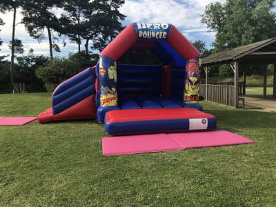 13x16 Superheroes Bouncy Castle with Slide, a bounce and slide combo for hire from Wallington Bouncy Castles