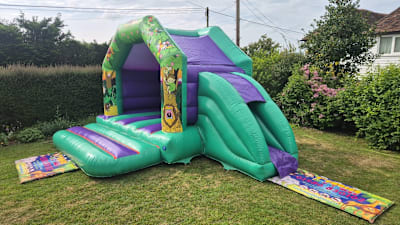 Slide Bouncer Bouncy Castle Jungle themed with Side Slide, a bounce and slide combo for hire from 1st Choice Inflatables