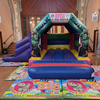 Hulk Slide 15ft x 18ft - Purple & Red, a inflatable slide for hire from Happy Hippos Bouncy Castles