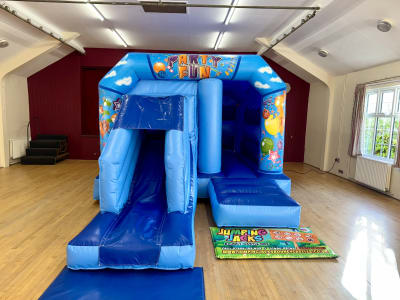 Blue Velcro castle with slide, a bounce and slide combo for hire from Jumping Jacks Bouncy Castles