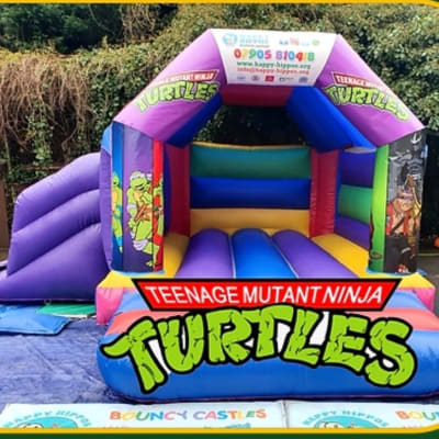 Teenage Mutant Ninja Turtles Slide 15ft x 18ft - Purple & Red, a inflatable slide for hire from Happy Hippos Bouncy Castles