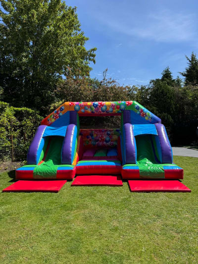 15x18ft Multicoloured Party Double Front Slide Combi, a bounce and slide combo for hire from Bouncing Happy