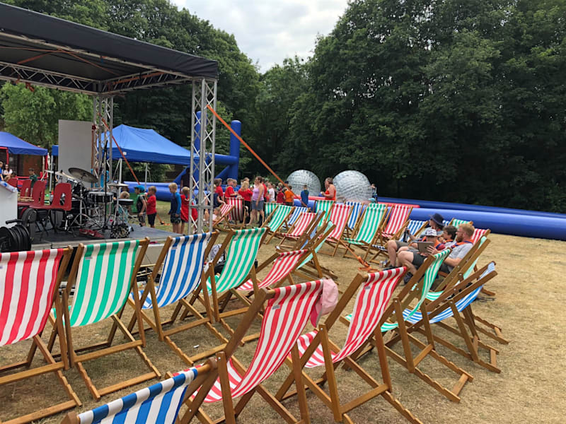 Rows of striped deck chairs set out in front of an event stage